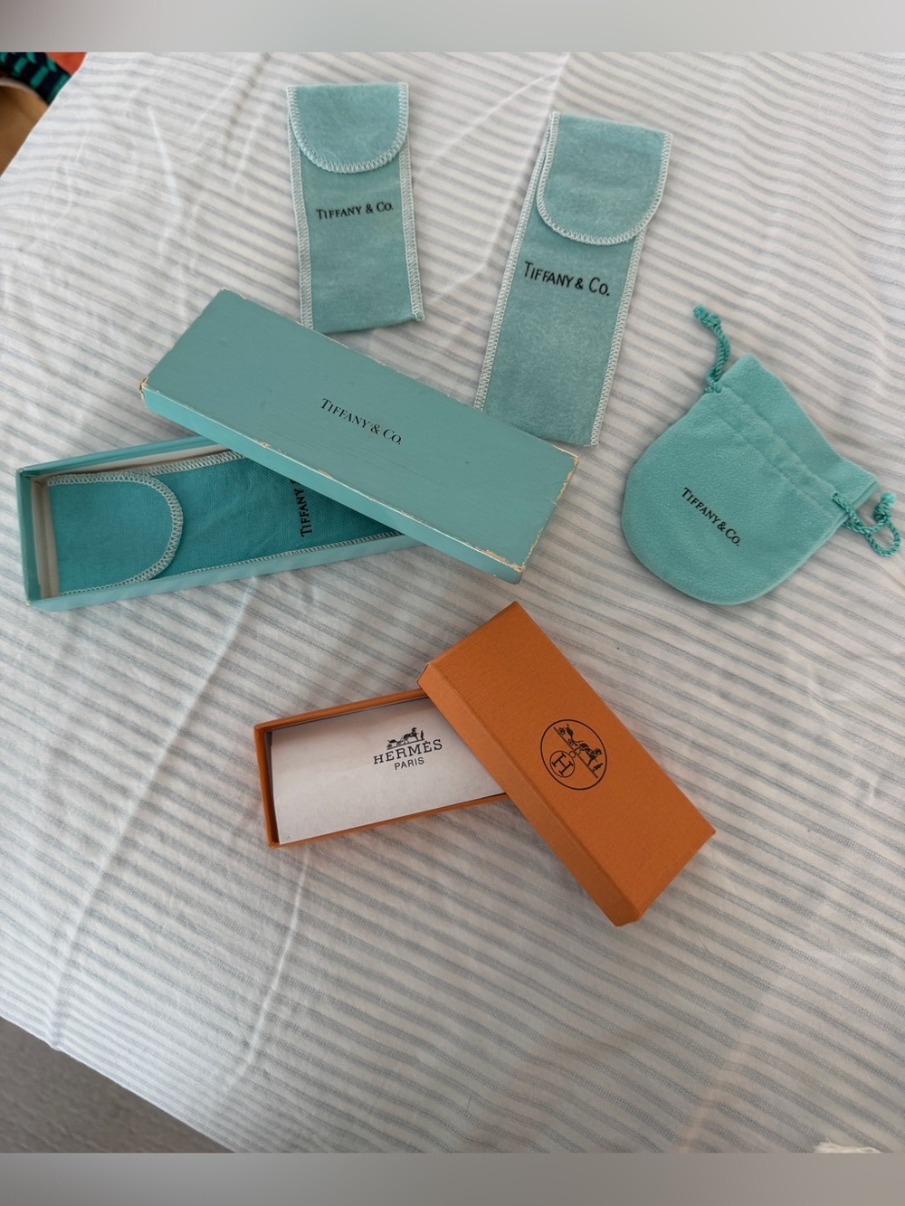 Lot of four Tiffany & Co. pouches, one Tiffany box, and one Hermes keychain box
